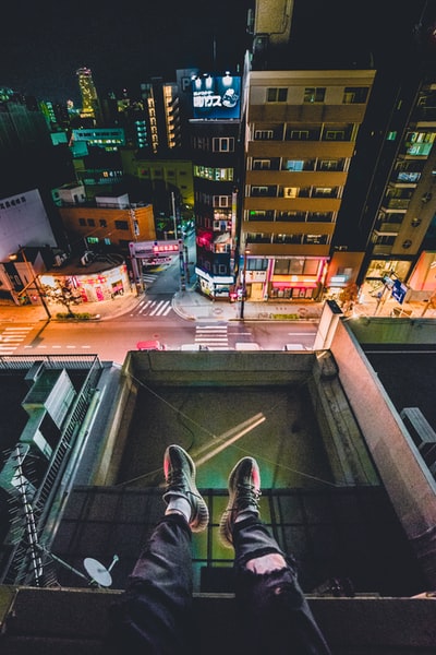 坐在屋顶上俯瞰城市的男子
